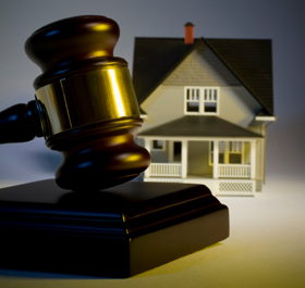 Photo of gavel in front of small toy home